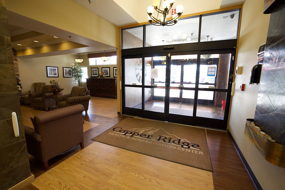 Front door with logo floor mat at Copper Ridge Health and Rehab
